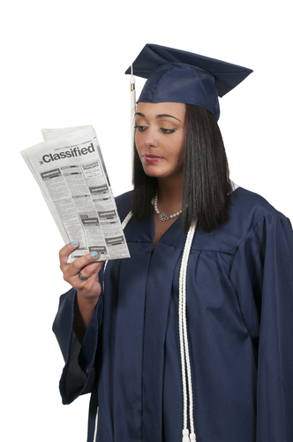 Woman looks in the classifieds to find a job after graduating