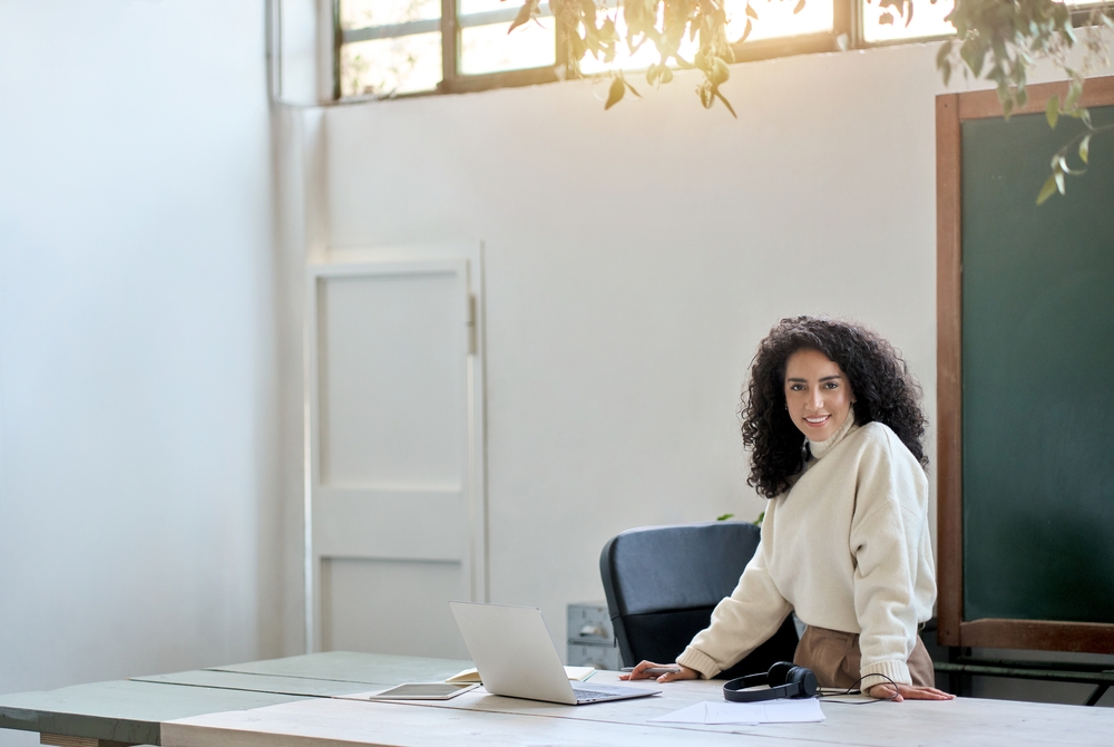 Woman smiling behind desk.