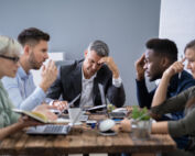 A group of coworkers stressed about a conflict.